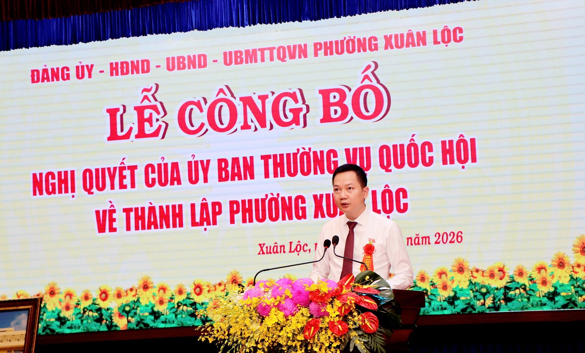 'A person standing at a podium with a microphone and flowers

AI-generated content may be incorrect.'