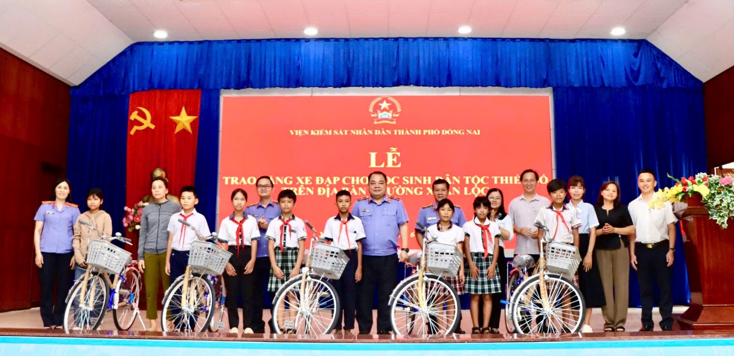 'A group of people standing on a stage with bicycles

AI-generated content may be incorrect.'